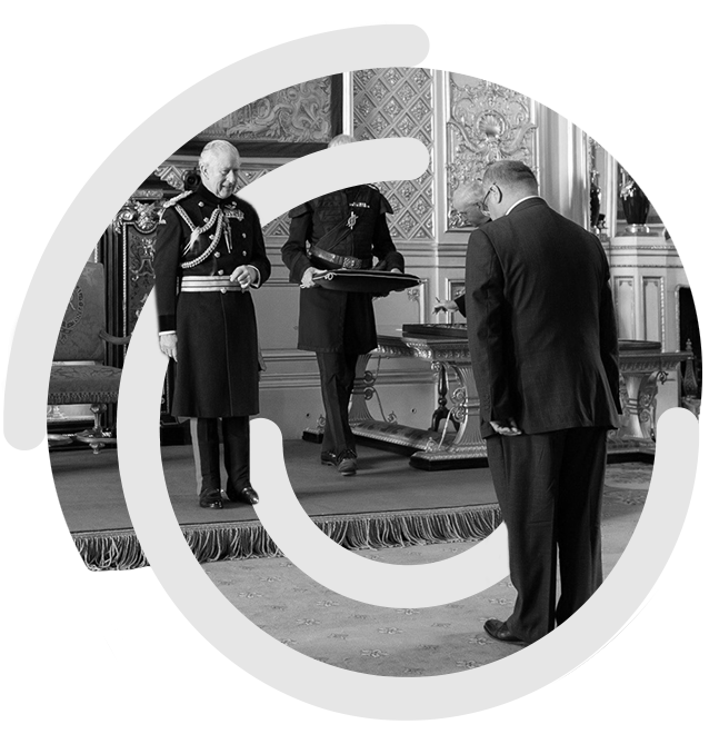 Amir receiving OBE from King