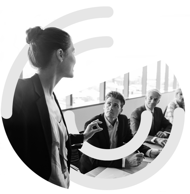 Lady presenting to team members around desk